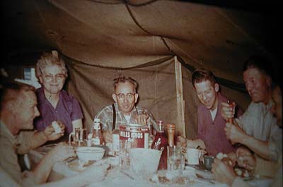 Family around the dinner table in the tent.